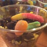 These popcorn and seed based Worms in Dirt Cups are a healthier alternative to the traditional cookie or pudding based cups. Made with foods that birds actually eat, this Healthier “Worms in Dirt Cup” Treat is a great compliment to a DIY Bird Feeder activity for school, Girl Scouts, or Cub Scouts. #pineconebirdfeeders #wormsindirtcups