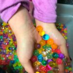 We recently discovered the magical world of Orbeez / water beads and now my kids are obsessed! Learn how to make this super fun Magical Rainbow Water Bead Bin. It’s great for kids of all ages. And I have to admit, I thought it was pretty magical as well. #kidsactivities #waterbeads #sensoryactivities