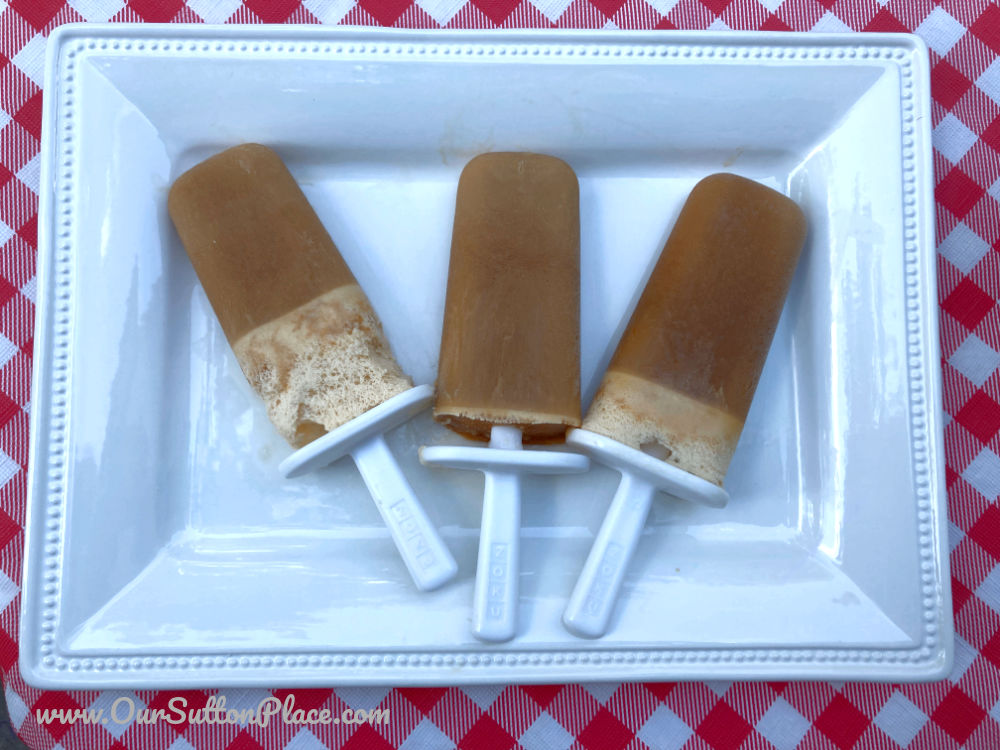 Flat lay view of 3 root beer float smoothie popsicles on a plate