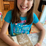 picture of girl creating a Paper Bag Gingerbread house