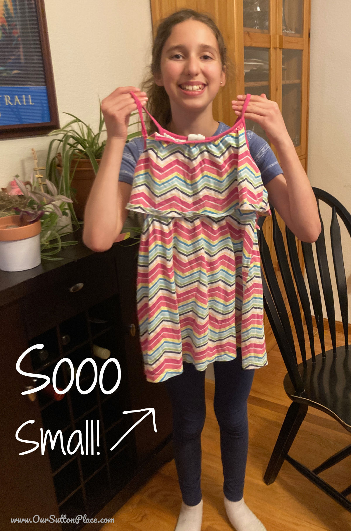 tween holding up old striped dress to upccyle