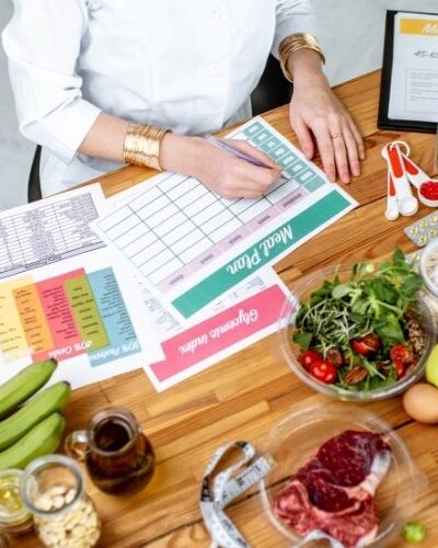 picture of a woman meal planning at a table covered in healthy food